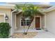 Close-up of the front door, framed by columns and small palm trees at 3189 Seattle Ave, North Port, FL 34286