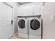 This is a laundry room featuring a full-sized washer and dryer and white cabinets above at 3189 Seattle Ave, North Port, FL 34286