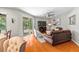 Bright living room featuring hardwood floors, a ceiling fan, and sliding glass doors to the outside at 3189 Seattle Ave, North Port, FL 34286