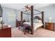 Ornate main bedroom with canopy bed, ceiling fan, and matching dressers and end tables at 3189 Seattle Ave, North Port, FL 34286