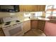 Functional kitchen with white appliances, wood cabinets, and natural light from the adjacent sunroom at 3333 26Th E Ave # 28, Bradenton, FL 34208