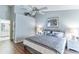 Cozy bedroom with a decorative ceiling fan, wood floors, and a view to the bathroom at 3815 Muirfield Ct, Palm Harbor, FL 34685