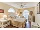 Bright bedroom showcasing wicker furniture, ceiling fan, and modern flooring at 3815 Muirfield Ct, Palm Harbor, FL 34685