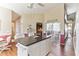 Open kitchen with island, white cabinets, and view to living room at 3815 Muirfield Ct, Palm Harbor, FL 34685