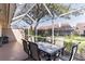 Screened patio with outdoor dining set and view of the landscaped backyard at 3815 Muirfield Ct, Palm Harbor, FL 34685