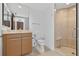 Bathroom featuring light wood cabinets, a glass shower, and light tile flooring at 401 S Palm Ave # 801, Sarasota, FL 34236