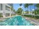 A tranquil pool reflecting blue skies with poolside lounge chairs for relaxation at 401 S Palm Ave # 801, Sarasota, FL 34236