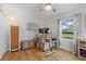 Comfortable bedroom with a ceiling fan, a beach-themed TV, and a functional workspace with a large window at 4023 Center Pointe Pl # 3A, Sarasota, FL 34233