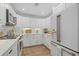 Clean kitchen featuring white cabinets, stainless steel appliances, stone countertops, and hardwood floors at 4023 Center Pointe Pl # 3A, Sarasota, FL 34233