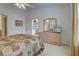 Spacious bedroom featuring an ensuite bath, ceiling fan, and a large dresser with a mirror at 403 Auburn Lakes Cir # 403, Venice, FL 34292