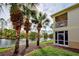 Two-story home with a screened-in balcony overlooking a tranquil pond and mature palm trees at 403 Auburn Lakes Cir # 403, Venice, FL 34292