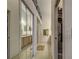 Hallway featuring tiled flooring, mirrored closet doors, and a view of the bathroom at 403 Auburn Lakes Cir # 403, Venice, FL 34292