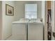 A laundry room with a washer and dryer, and white tiled floors at 403 Auburn Lakes Cir # 403, Venice, FL 34292