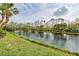 Scenic view of the neighborhood pond showcasing a tranquil waterfront setting with mature trees at 403 Auburn Lakes Cir # 403, Venice, FL 34292