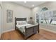 Cozy bedroom with a large arched window providing natural light and wood flooring at 4623 Claremont Park Dr, Lakewood Ranch, FL 34211