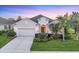 Charming single-story home with a well-manicured lawn, lush landscaping, and an attached two-car garage at 4623 Claremont Park Dr, Lakewood Ranch, FL 34211