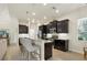 Modern kitchen featuring dark cabinetry, stainless steel appliances, and a granite-topped breakfast bar at 4623 Claremont Park Dr, Lakewood Ranch, FL 34211