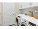 Laundry room featuring modern washer and dryer units and ample storage cabinets at 4623 Claremont Park Dr, Lakewood Ranch, FL 34211