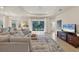 Bright living room with a cozy sectional sofa, backyard access, and an entertainment center at 4623 Claremont Park Dr, Lakewood Ranch, FL 34211