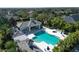 Aerial view of a community pool with a jacuzzi, covered seating, and sun umbrellas at 4623 Claremont Park Dr, Lakewood Ranch, FL 34211