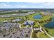 Community aerial view featuring a golf course, large pool, clubhouse, lakes, and manicured landscapes at 4735 Trento Pl, Bradenton, FL 34211