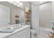 Bright bathroom featuring white cabinets, large mirror, and shower and tub combo at 4735 Trento Pl, Bradenton, FL 34211