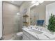 Bright bathroom featuring shower with glass enclosure, large mirror, and white cabinets at 4735 Trento Pl, Bradenton, FL 34211