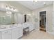 Bright bathroom featuring double vanity, white cabinets, and ensuite access to walk-in closet at 4735 Trento Pl, Bradenton, FL 34211