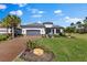 Beautiful single-story home with a well-manicured lawn, a brick driveway, and a two-car garage at 4735 Trento Pl, Bradenton, FL 34211