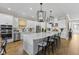 Open kitchen featuring a large island with seating, stainless steel appliances, and white cabinets at 4735 Trento Pl, Bradenton, FL 34211