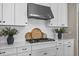 Close-up of the kitchen with white cabinetry, stainless steel hood, and decorative tile backsplash at 4735 Trento Pl, Bradenton, FL 34211