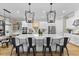 Open kitchen featuring white cabinets, a large island with seating, and modern pendant lighting at 4735 Trento Pl, Bradenton, FL 34211