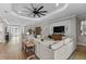 Bright living room with tray ceiling, and open floor plan, featuring a large sectional sofa and wood flooring at 4735 Trento Pl, Bradenton, FL 34211