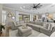 Open concept living area with large sectional sofa, decor pillows, and view to outdoor lanai and kitchen at 4735 Trento Pl, Bradenton, FL 34211