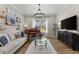 Elegant living room featuring a piano, modern chandelier, and light-filled window at 4735 Trento Pl, Bradenton, FL 34211