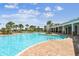 Gorgeous community pool with ample seating, lush landscaping, and a covered lounge area for relaxation at 4918 Gray Owl Ter, Palmetto, FL 34221