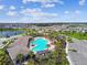 Aerial view of a community pool area with palm trees, pergolas, and lounge chairs at 4918 Gray Owl Ter, Palmetto, FL 34221