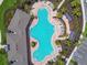Aerial view of resort-style community pool, sun-drenched lounge area, lush landscaping, and convenient parking at 4918 Gray Owl Ter, Palmetto, FL 34221