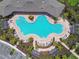 Aerial view of a resort-style community pool, sun-soaked lounge area, and expertly manicured landscaping at 4918 Gray Owl Ter, Palmetto, FL 34221