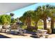 Charming outdoor seating area with stone tables, benches, and views of palm trees and landscaping at 503 Albee Farm Rd # B6, Venice, FL 34285
