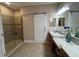 Bright bathroom featuring dual sinks with marble countertops, tiled floors and a glass shower at 5031 Serata Dr, Bradenton, FL 34211