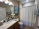 Bathroom showcasing vanity, toilet, and a shower with a white curtain and a decorative picture at 5031 Serata Dr, Bradenton, FL 34211