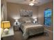 Cozy bedroom with ceiling fan, white dresser and nightstands, and a framed floral print above the bed at 5031 Serata Dr, Bradenton, FL 34211