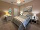 Bedroom with a ceiling fan, white dresser, nightstands, and a floral print hanging above the bed at 5031 Serata Dr, Bradenton, FL 34211