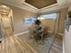 Cozy dining room features a glass-topped table, a classic chandelier, and a serene ambiance for intimate gatherings at 5031 Serata Dr, Bradenton, FL 34211