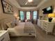 Spacious carpeted main bedroom featuring tray ceilings, bay window, and a large dresser at 5031 Serata Dr, Bradenton, FL 34211