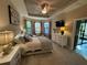 Main bedroom with carpet, tray ceiling, bay window, dresser, and exterior door at 5031 Serata Dr, Bradenton, FL 34211