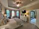 Carpeted main bedroom featuring tray ceilings, bay window, large dresser, and an exterior door at 5031 Serata Dr, Bradenton, FL 34211
