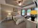 Spacious main bedroom with a tray ceiling, carpet flooring, and a bay window at 5031 Serata Dr, Bradenton, FL 34211
