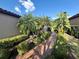 Paver path between homes is landscaped with palms, and lush tropical plants at 5031 Serata Dr, Bradenton, FL 34211